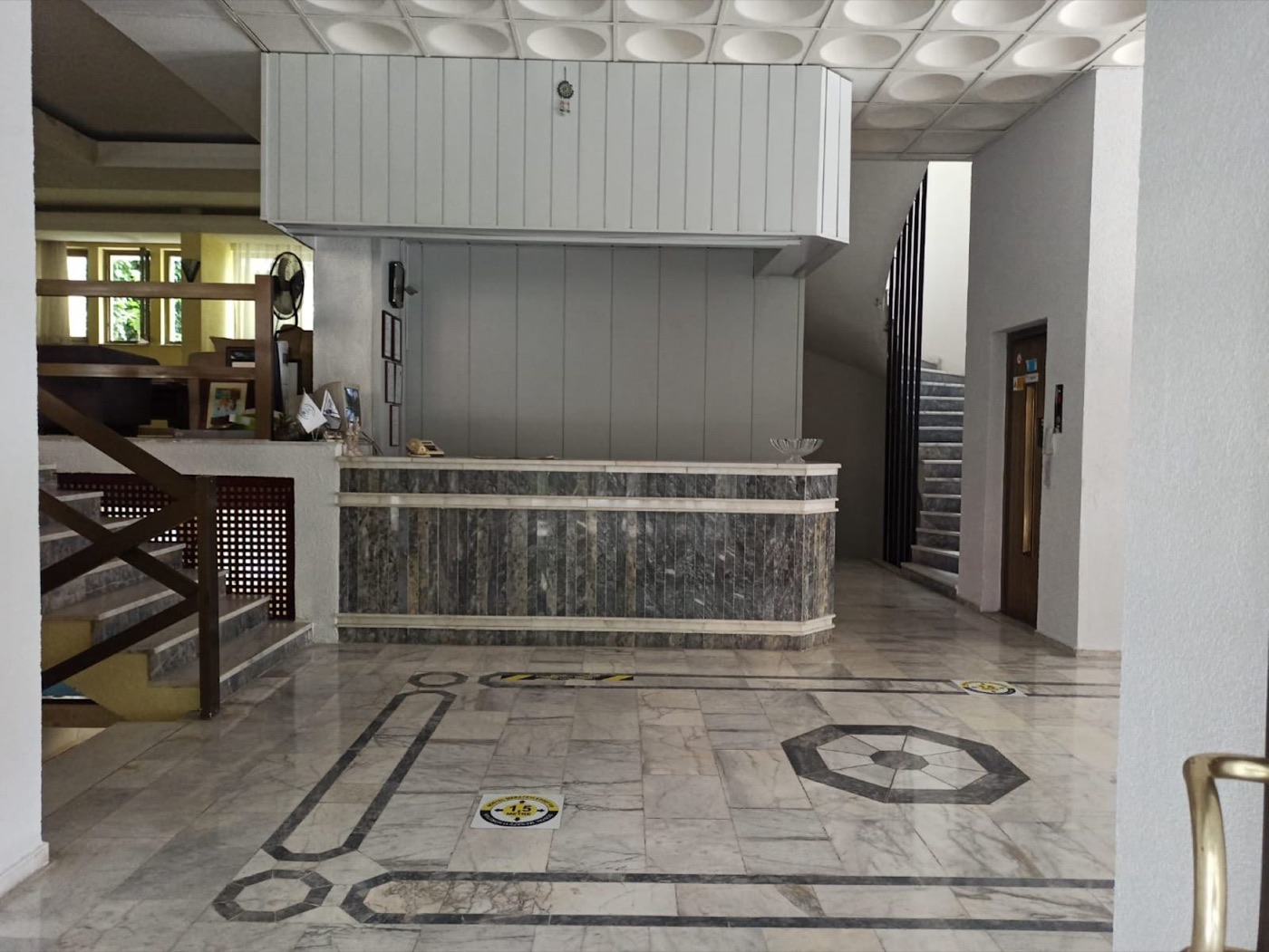 Dias Hotel lobisi: mermer zemindeki sekizgen desen ve mermer kaplı resepsiyon bankosu
